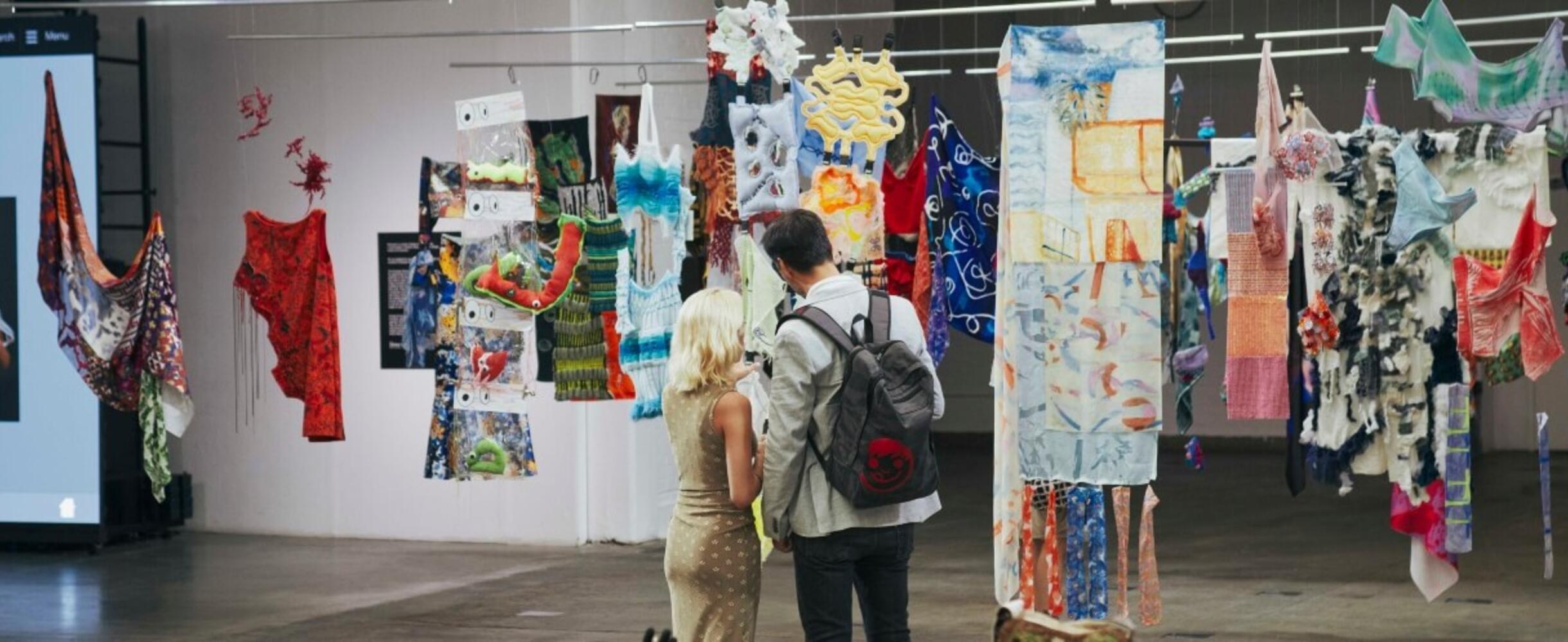 Two people visit a fashion exhibit