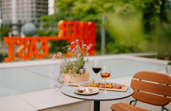 2 wine glasses and food at a table on the rooftop restaurant at Riverside East