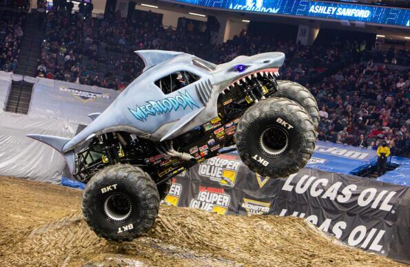 A Monster Jam truck designed like a shark balances on two wheels