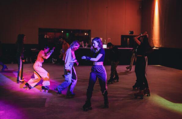 A group of people roller-skating indoors