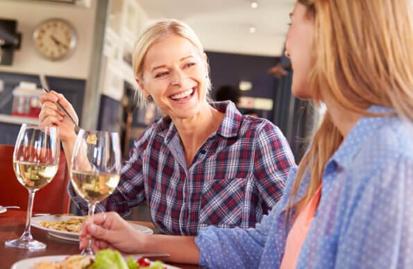 Two women have dinner together with wine glasses