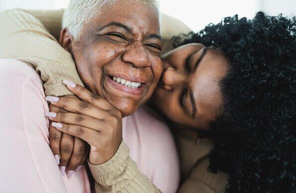 Two women hug with smiles