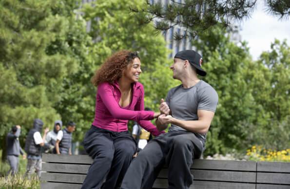 A couple sits on a bench in the Queen Elizabeth Olympic Park