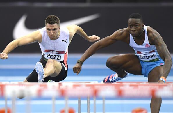 two runners mid-hurdle