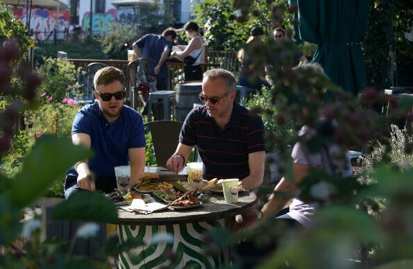 A group of people dining outside in Barge East gardens