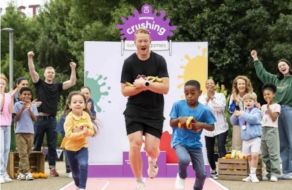 Olympian Greg Rutherford running a race with children at an Innocent Smoothies brand activation