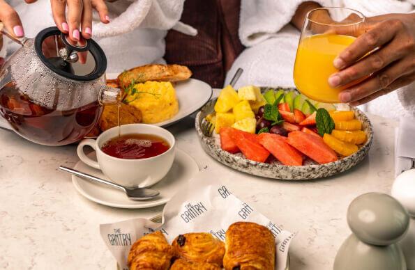 Breakfast food on a table with two people sat behind