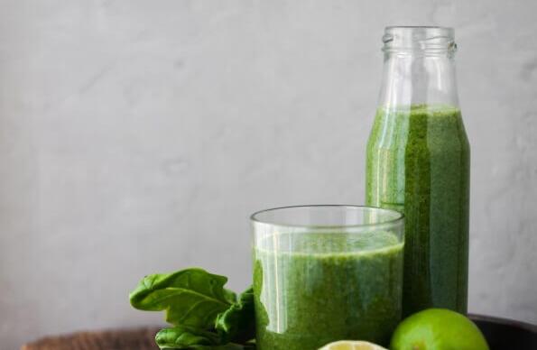 A tray of limes, apples and green juice