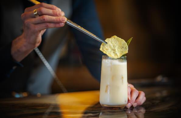 A bartender garnishing a cocktail