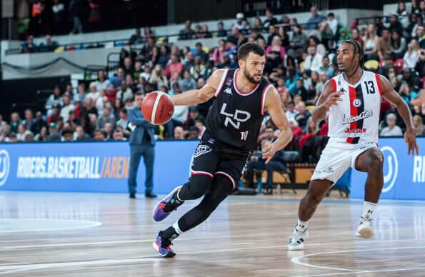 A London Lions basketball player runs past an opposing player