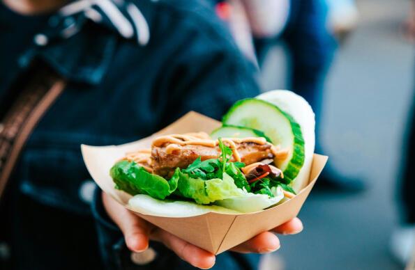 A box of street food with salad is held up to the camera A box of street food with salad is held up to the camera