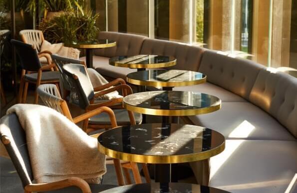 A row of tables and couches in a cocktail bar