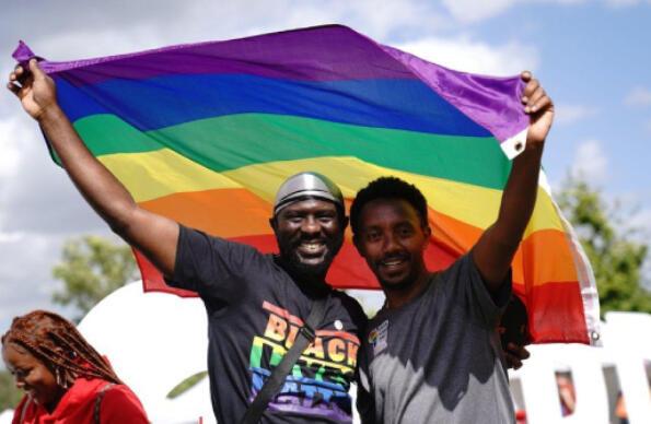 Two men holding up the pride flag at UK Black Pride