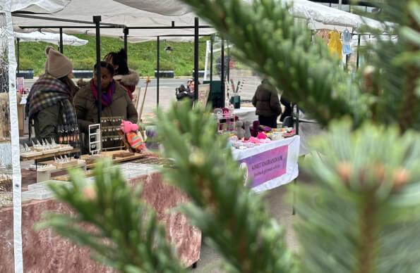 Stalls at the Hackney Bridge x-mas market behind a christmas tree