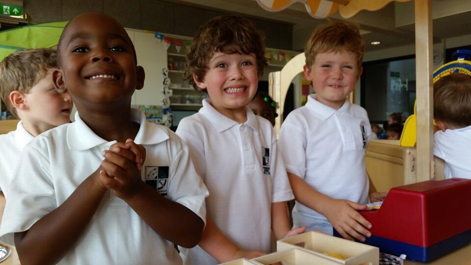 Schoolchildren smiling for photo inside of classroom