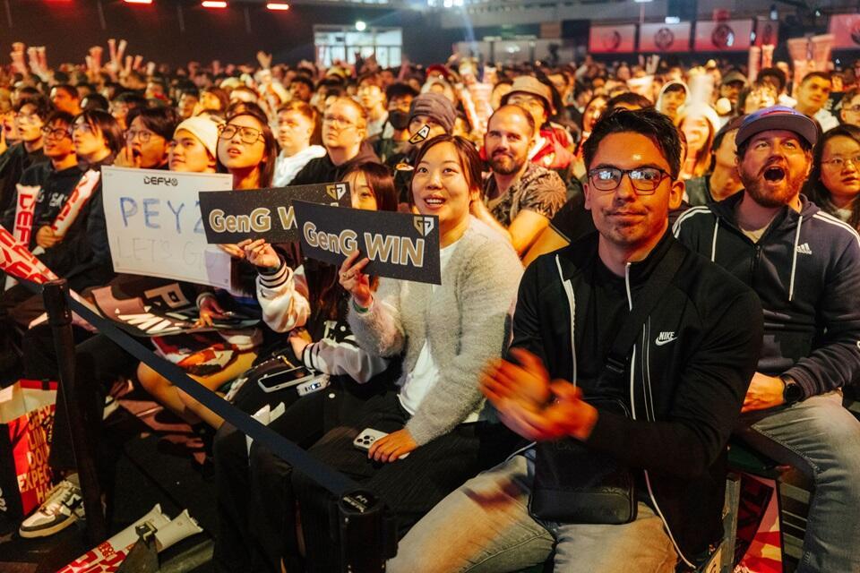 Crowd of people holding signs at basketball game