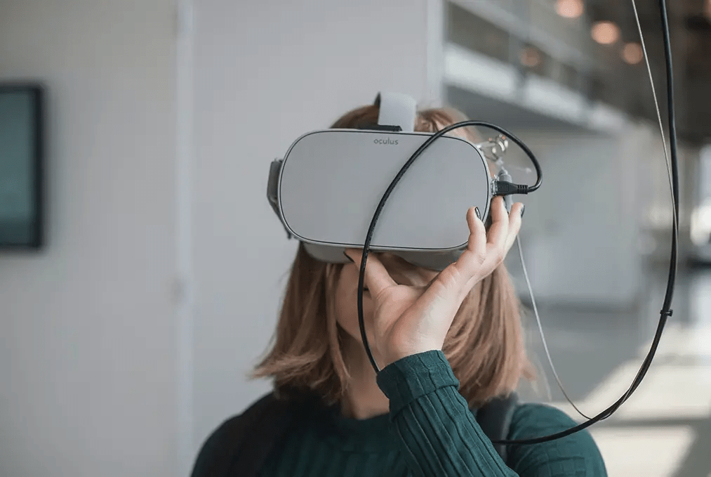 A women holds a VR headset up to her face