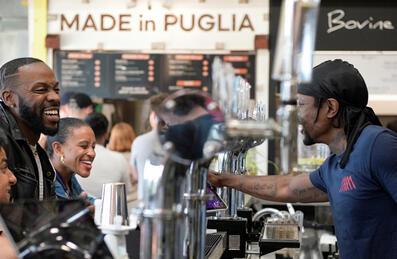 three people are being served drinks at the bar at Hackney Bridge