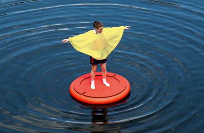 A participant of Discosailing stands on a float on water