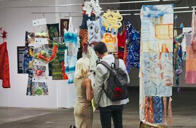 Two people visit a fashion exhibit