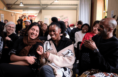 Women in an audience laughing and smiling