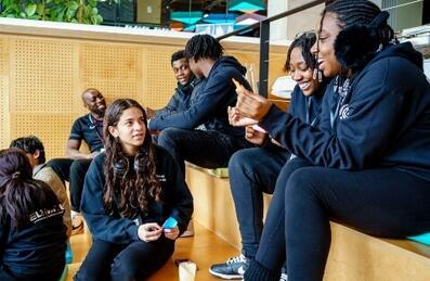 A group of teenagers wearing black chatting